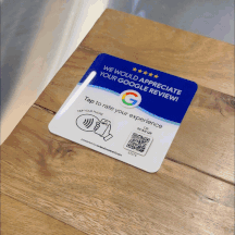GIF showing a ReviewBoost plaque on a wooden table. The plaque reads 